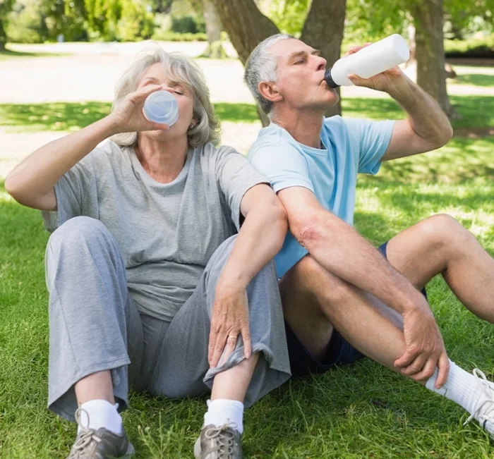 Mature couple drinking water outdoors